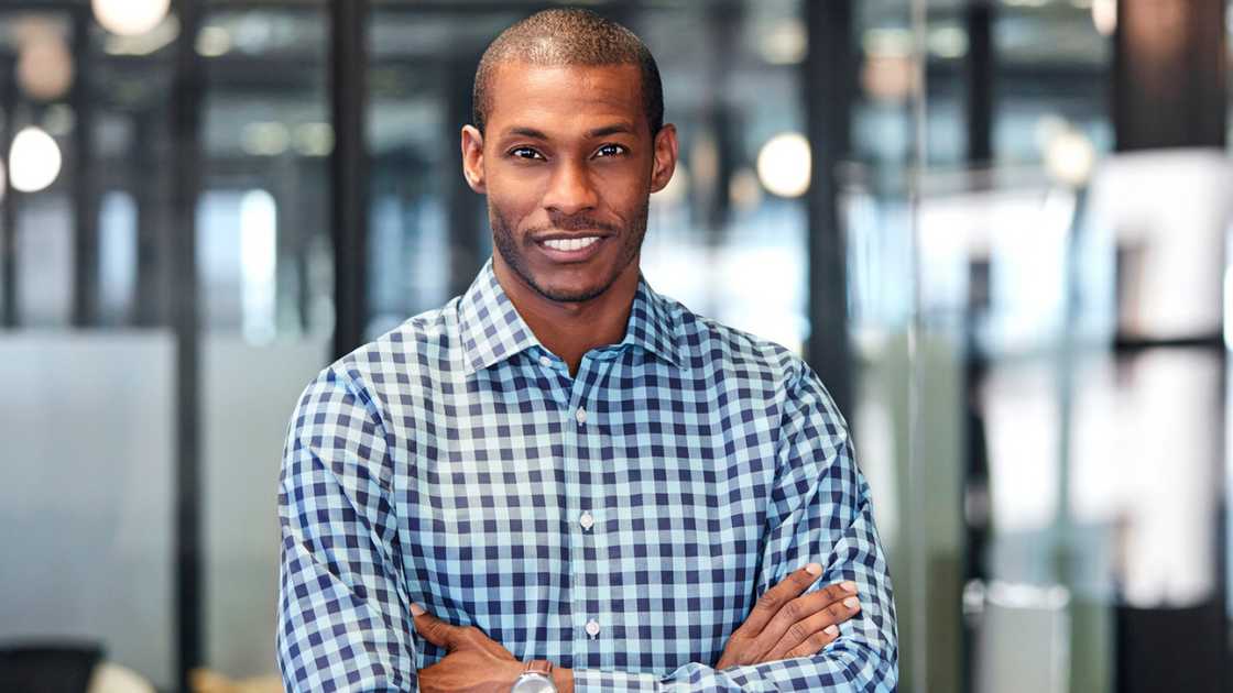 A man wearing blue checked pattern shirt in office.