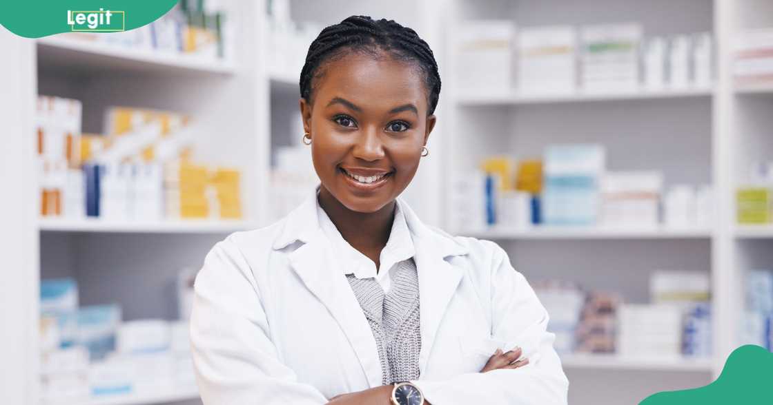 A female pharmacist poses with arms crossed in a healthcare clinic. A female pharmacist poses with arms crossed in a healthcare clinic.