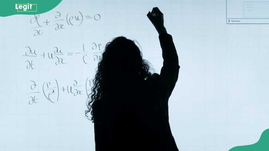 A teacher writing on a whiteboard