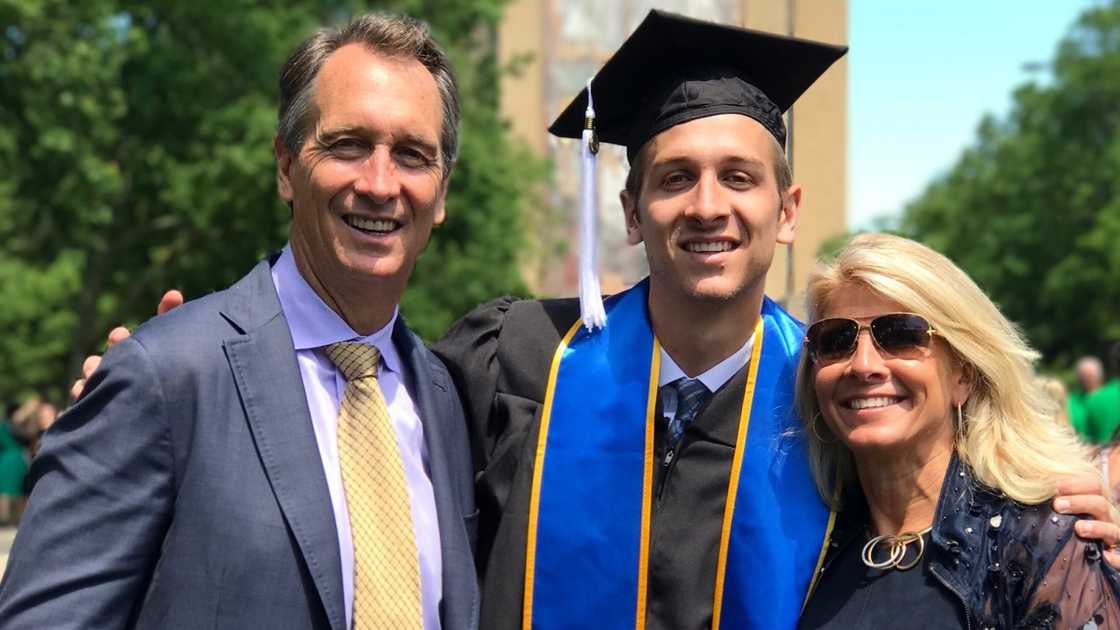 Cris Collinsworth poses with his wife and son during a graduation ceremony.