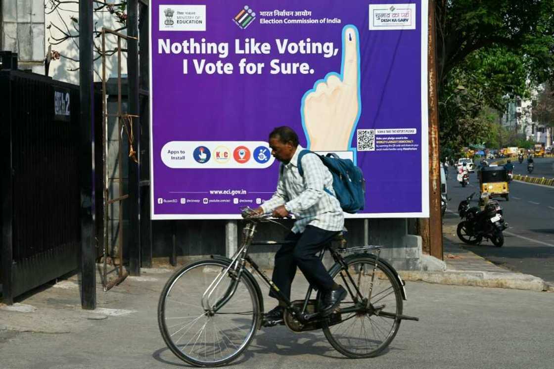 A man rides past an election awareness poster displayed on a street ahead of India’s upcoming general elections, in Hyderabad A man rides past an election awareness poster displayed on a street ahead of India’s upcoming general elections, in Hyderabad