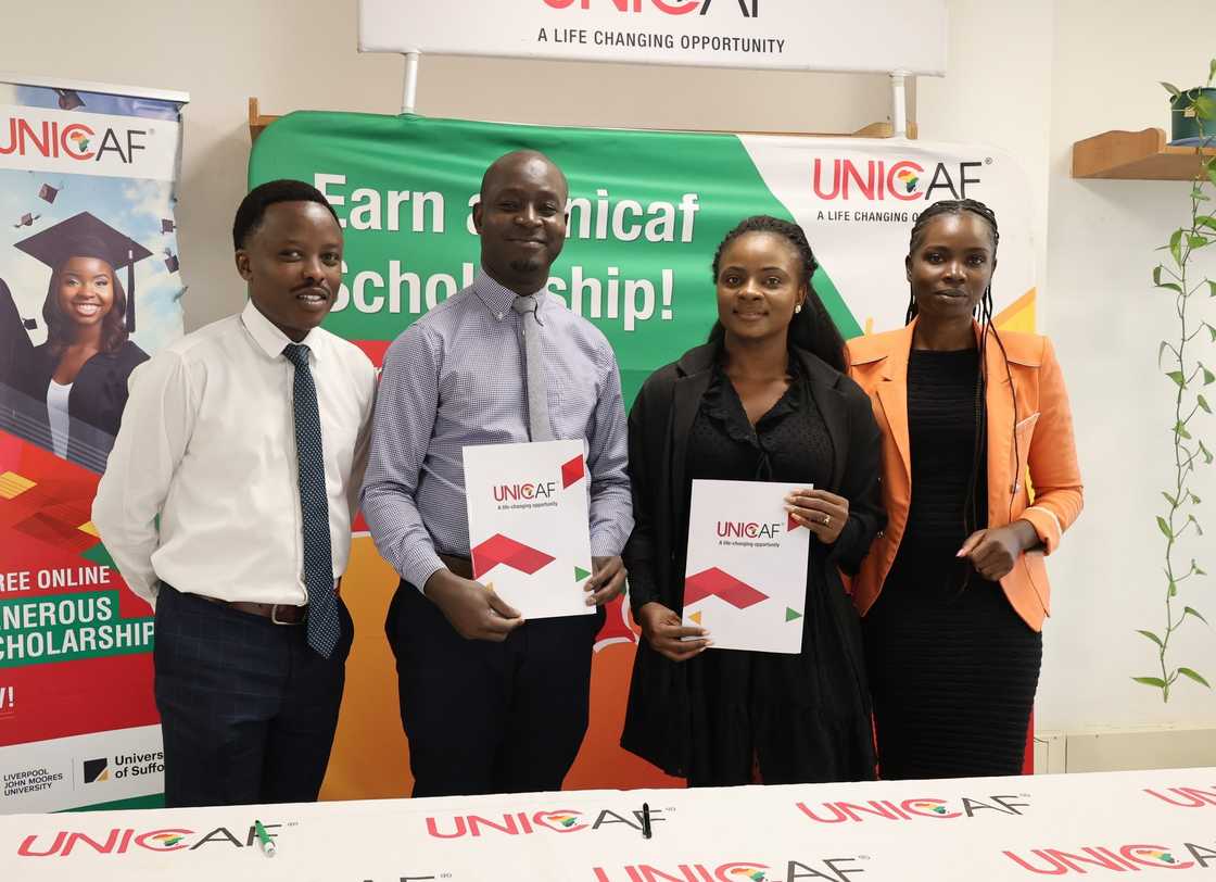 Students posing with the UNICAF booklet Students posing with the UNICAF booklet