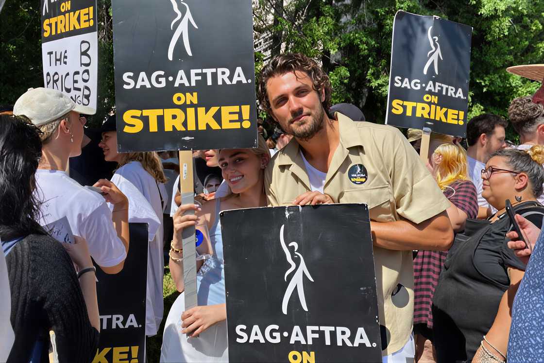 Meg Donnelly and Drake Rodger pose with placards during the 2023 SAG-AFTRA Supernatural picket Meg Donnelly and Drake Rodger pose with placards during the 2023 SAG-AFTRA Supernatural picket