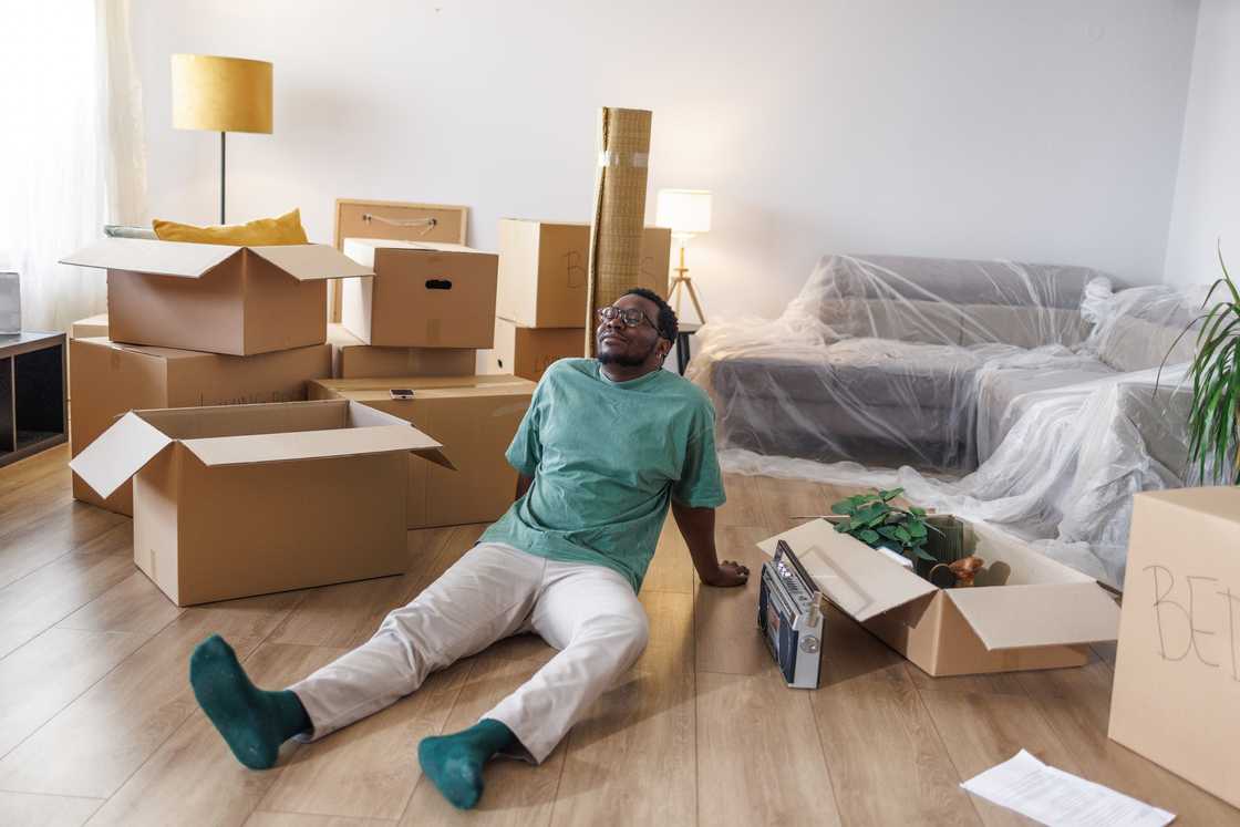 An office worker alone late at night in a messy apartment.