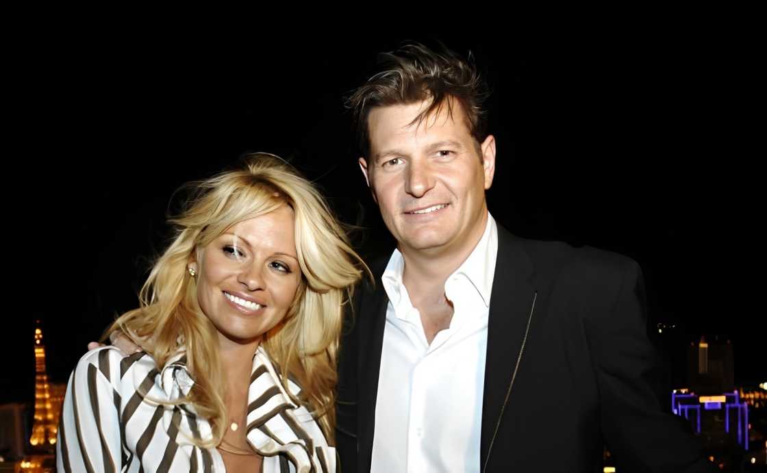 Pamela Anderson and Laurence Hallier smile as they pose for a photo Pamela Anderson and Laurence Hallier smile as they pose for a photo