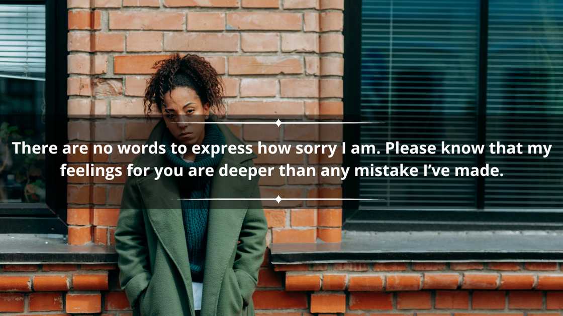 A woman in a green sweater and jacket leaning on a brick wall looking sad. A woman in a green sweater and jacket leaning on a brick wall looking sad.