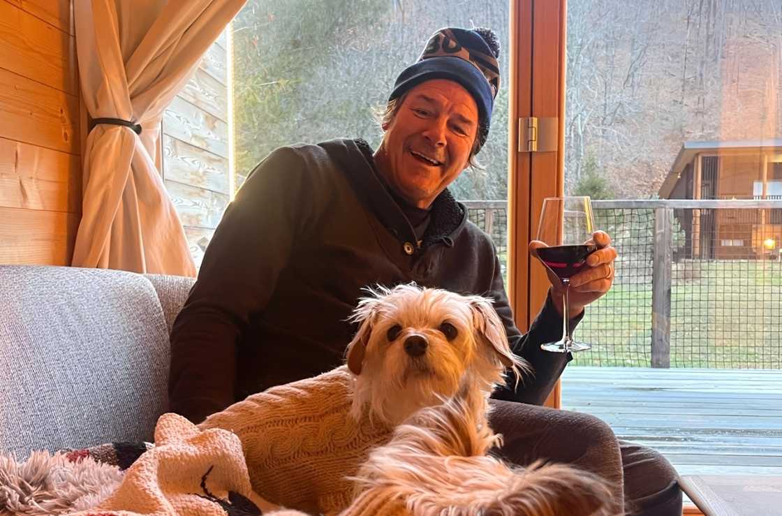 Ty Pennington posing with a dog and a glass of wine