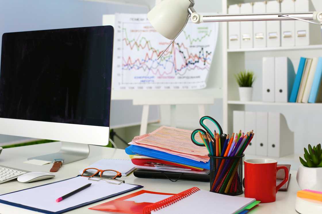 A computer and files on an office desk A computer and files on an office desk