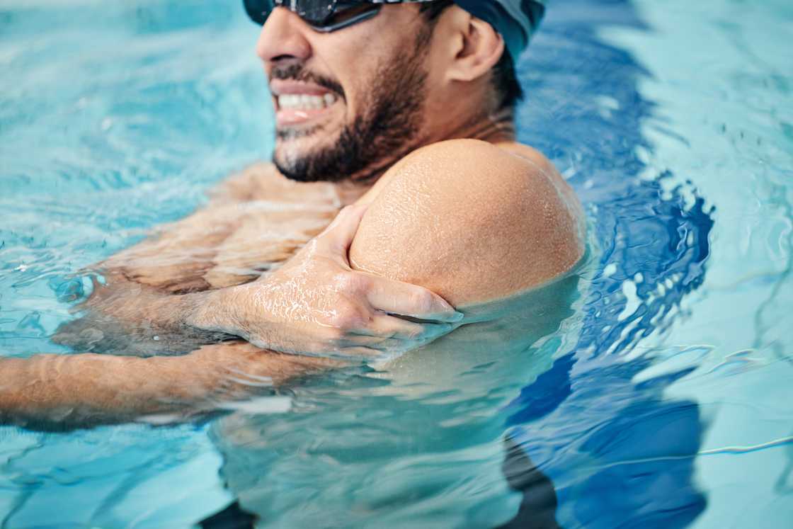 A man in a swimming pool with an injury and shoulder pain A man in a swimming pool with an injury and shoulder pain