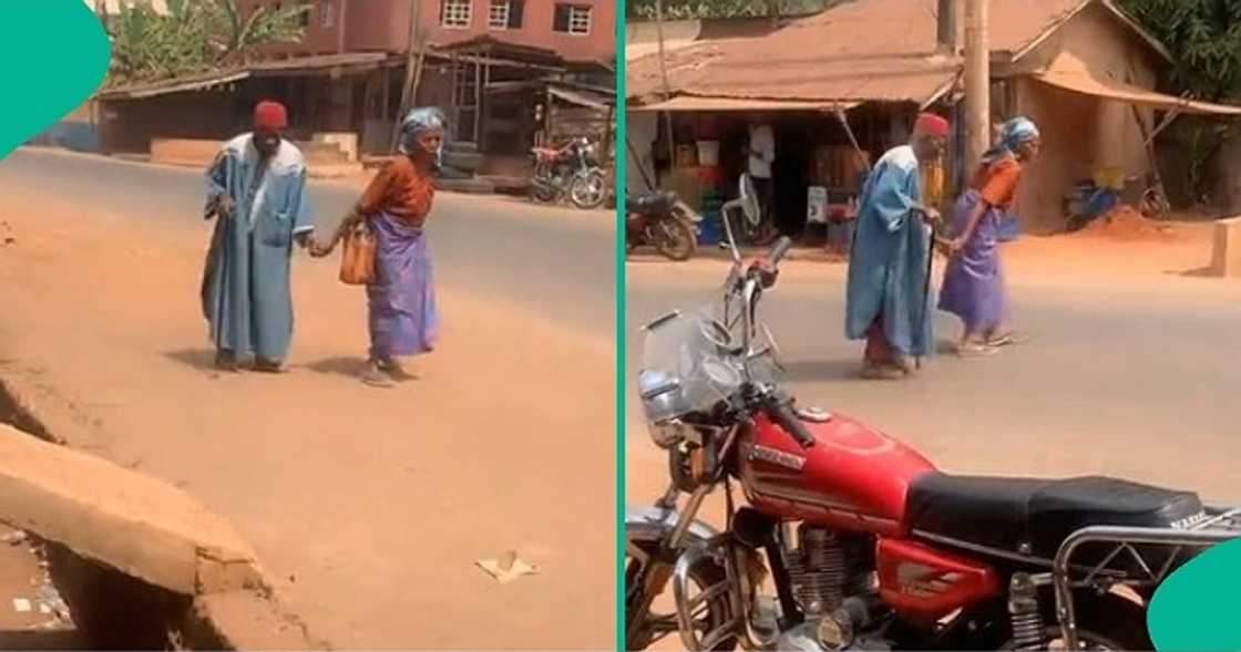 Old couple holds hands on road