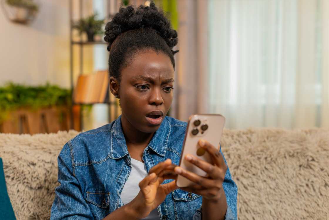 A lady holding her phone in shock