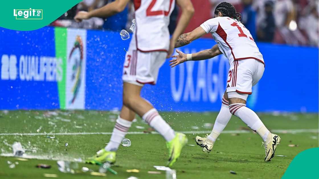 Players remove a bottle of water that fans throw on the pitch during a qualifier playoff between Qatar and United Arab Emirates in Qatar. Photo by: Noushad Thekkayil/NurPhoto.