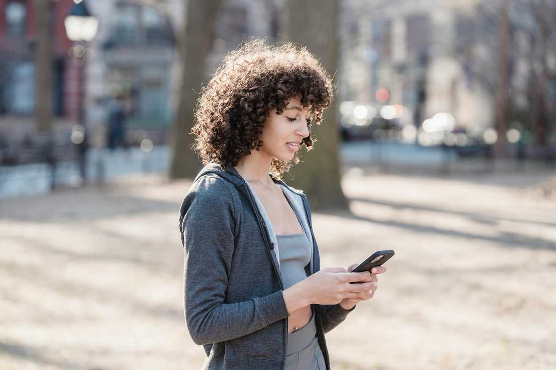 A woman using a smartphone in a park A woman using a smartphone in a park