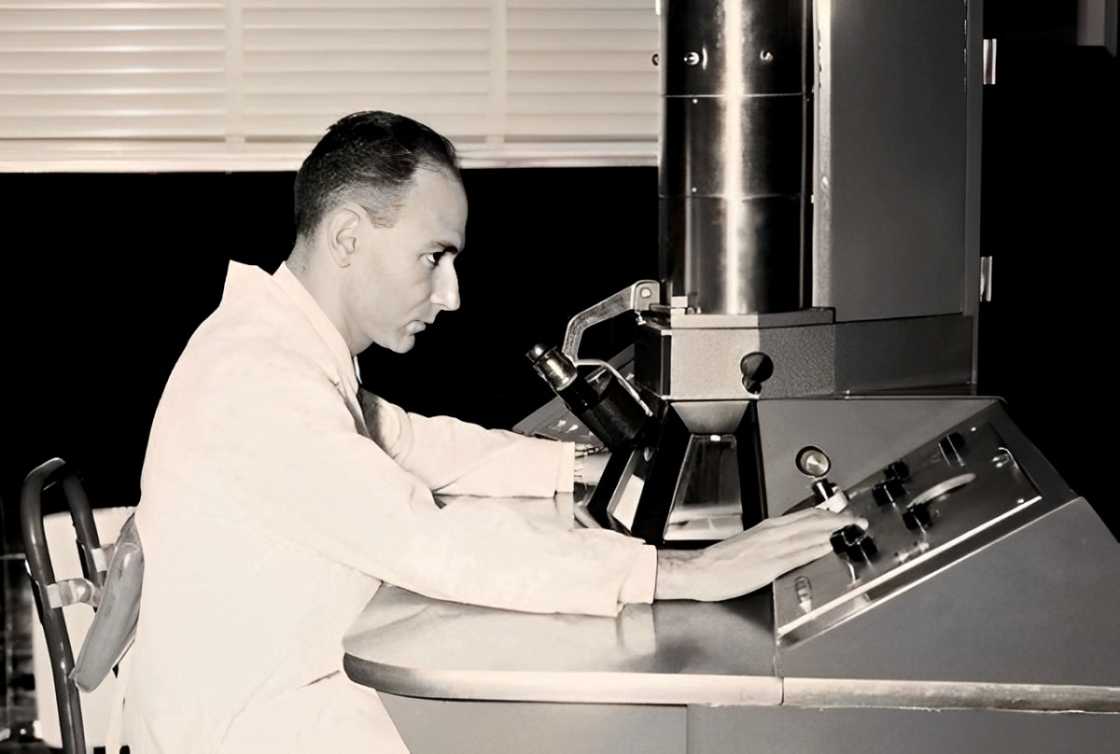 Humberto Fernández-Moran poses in front of a high-tech microscope. Humberto Fernández-Moran poses in front of a high-tech microscope.