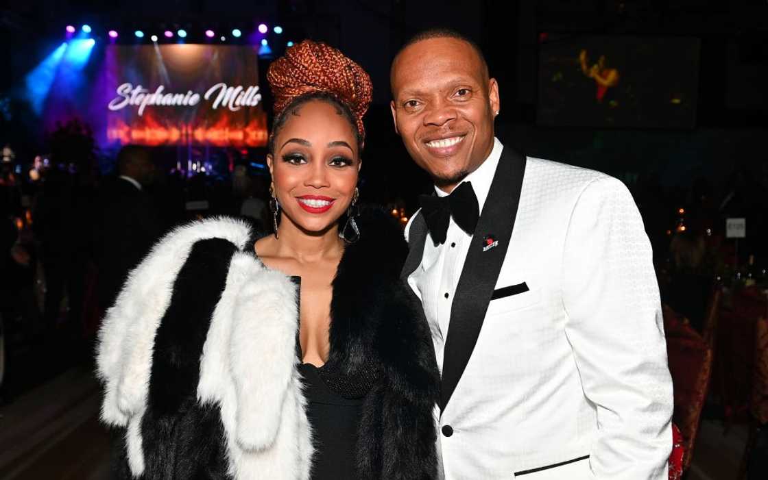 Shamari DeVoe and her husband, Ronnie DeVoe, in black and white outfits posing at Atlanta Marriott Marquis