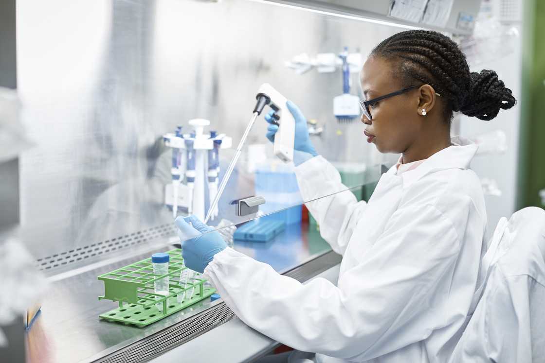 A female scientist analysing medical sample in a test tube. A female scientist analysing medical sample in a test tube.
