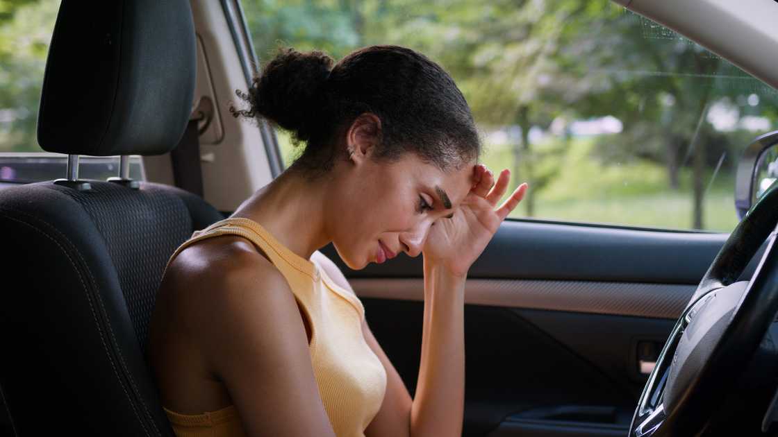 A depressed woman crying in a car
