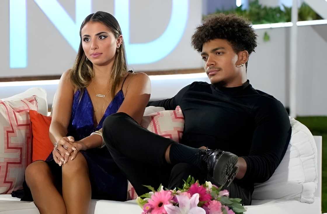 Phoebe Siegel and Chad Robinson sit on a white couch