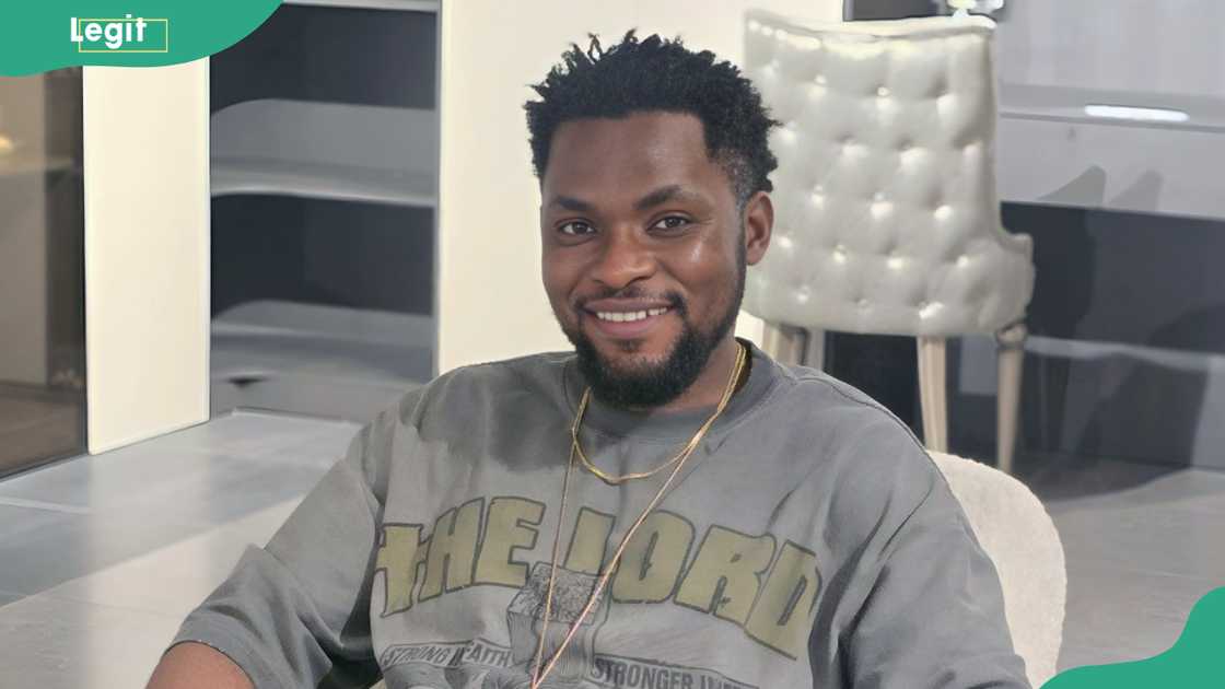 Mark Angel relaxing on a cushioned armchair with metal armrests