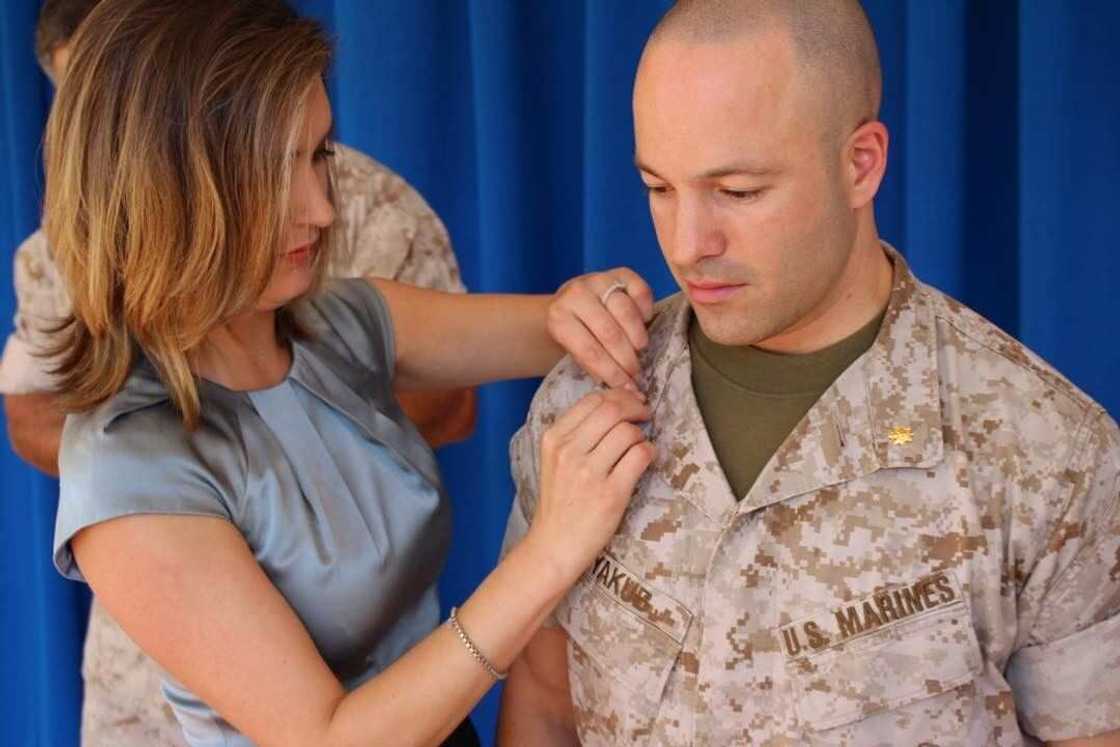 A woman pining a badge on Yado Yakub A woman pining a badge on Yado Yakub