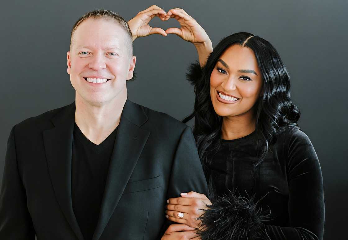 Gary Owen and Brianna Johnson pose together against a black background