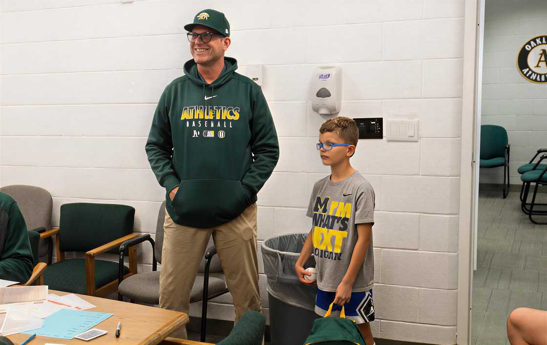 Jim Harbaugh stands with his son, Jack Harbaugh at the Oakland Athletics clubhouse