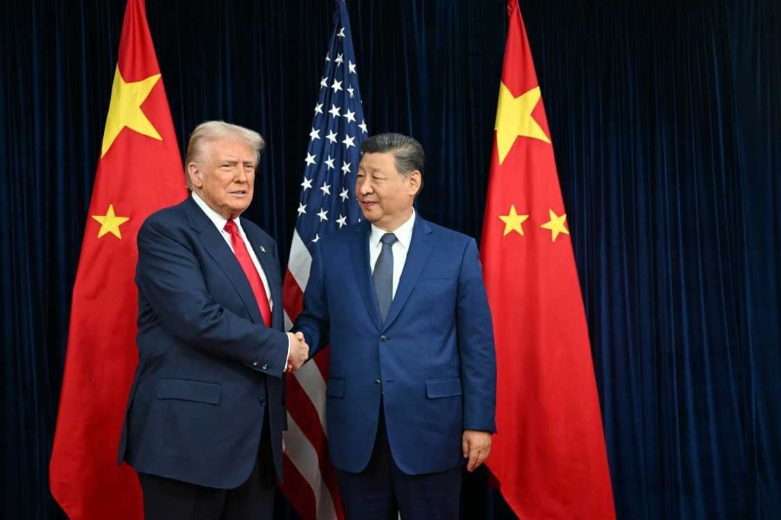 US President Donald Trump (L) and China's President Xi Jinping shake hands as they arrive for talks at the Gimhae Air Base, located next to the Gimhae International Airport in Busan on October 30, 2025