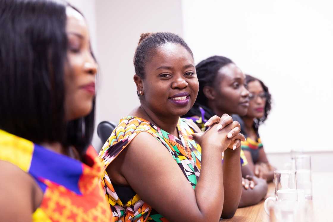 Women smiling during a stokvel meeting. Women smiling during a stokvel meeting.