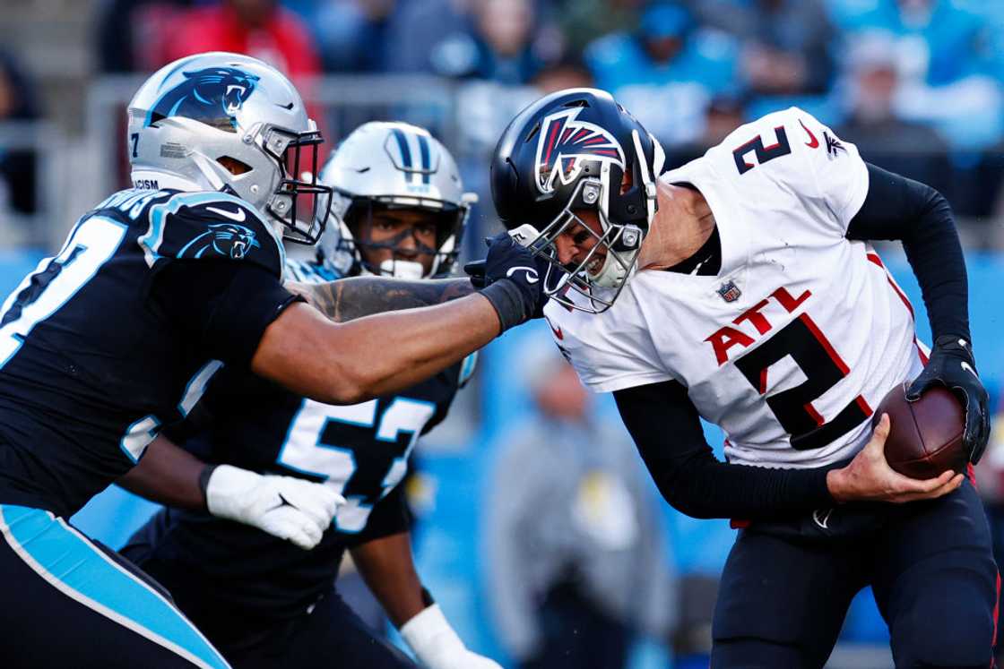 Matt Ryan #2 of the Atlanta Falcons has a face-mask penalty by Yetur Gross-Matos #97 of the Carolina Panthers at Bank of America Stadium