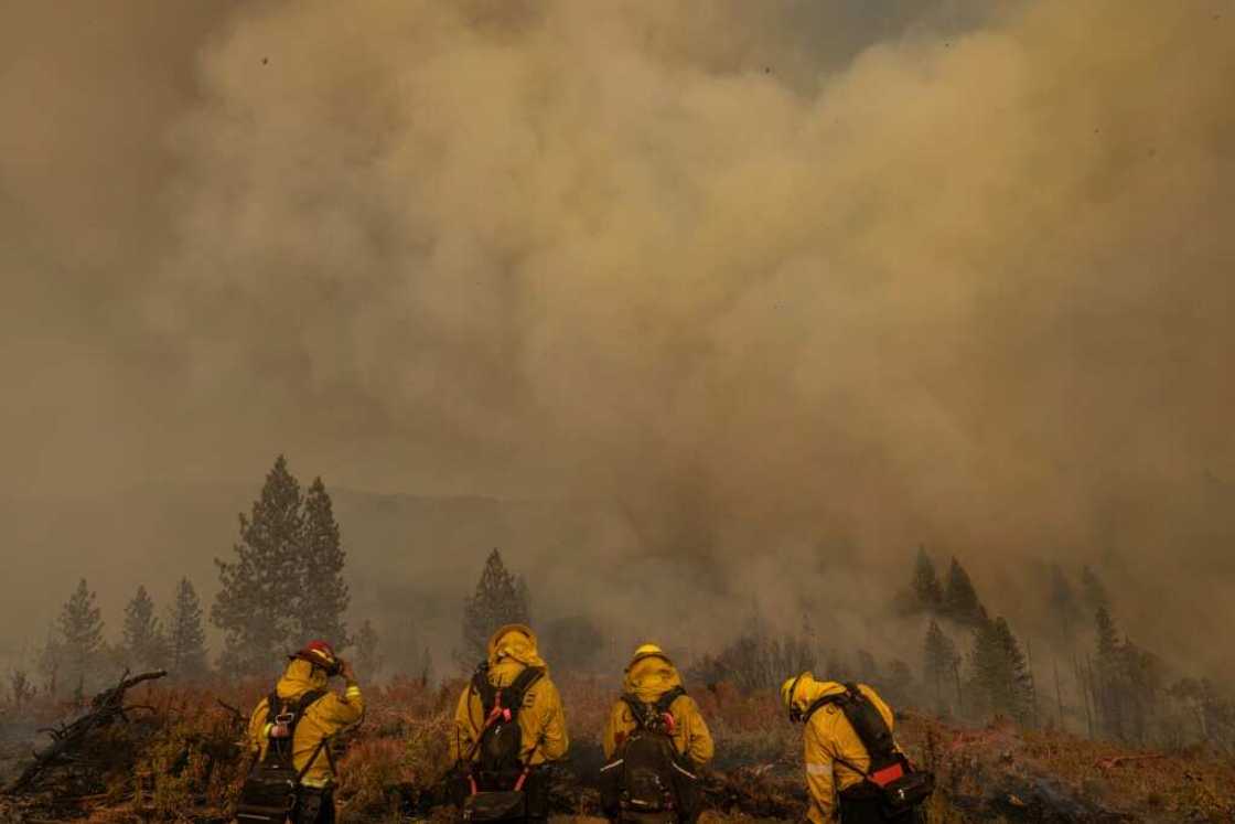 Smoke rises behind firefighters at at the Oak Fire in Mariposa, California Smoke rises behind firefighters at at the Oak Fire in Mariposa, California