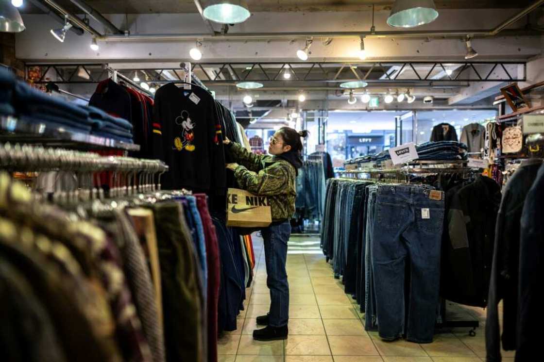 A customer visits a secondhand clothes shop in the Harajuku district of Tokyo A customer visits a secondhand clothes shop in the Harajuku district of Tokyo