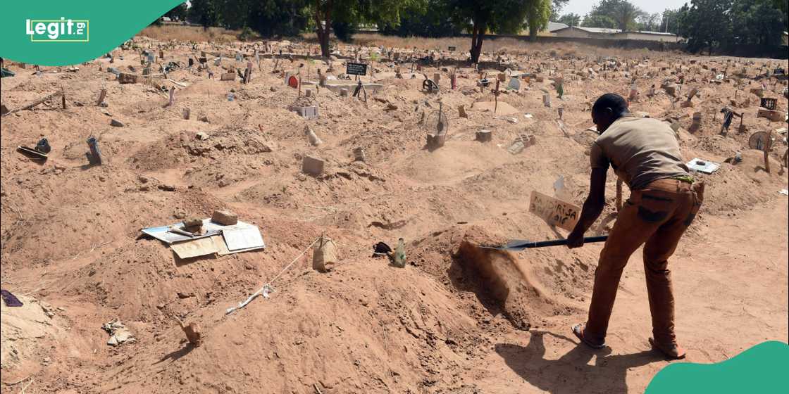 Man covers grave with sand.