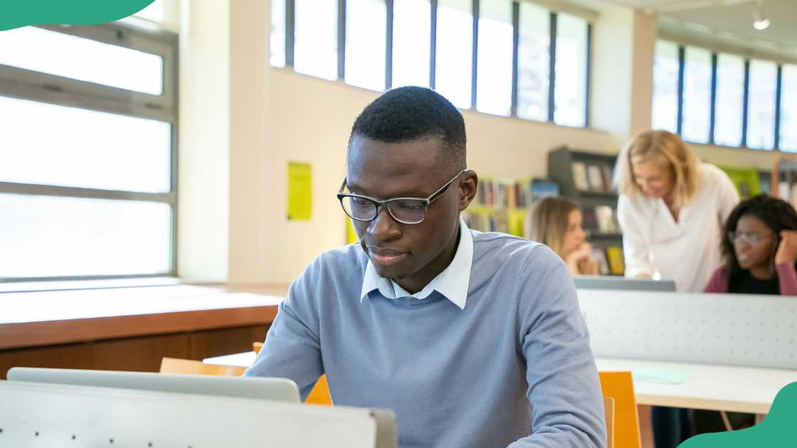 A young man studies in a library