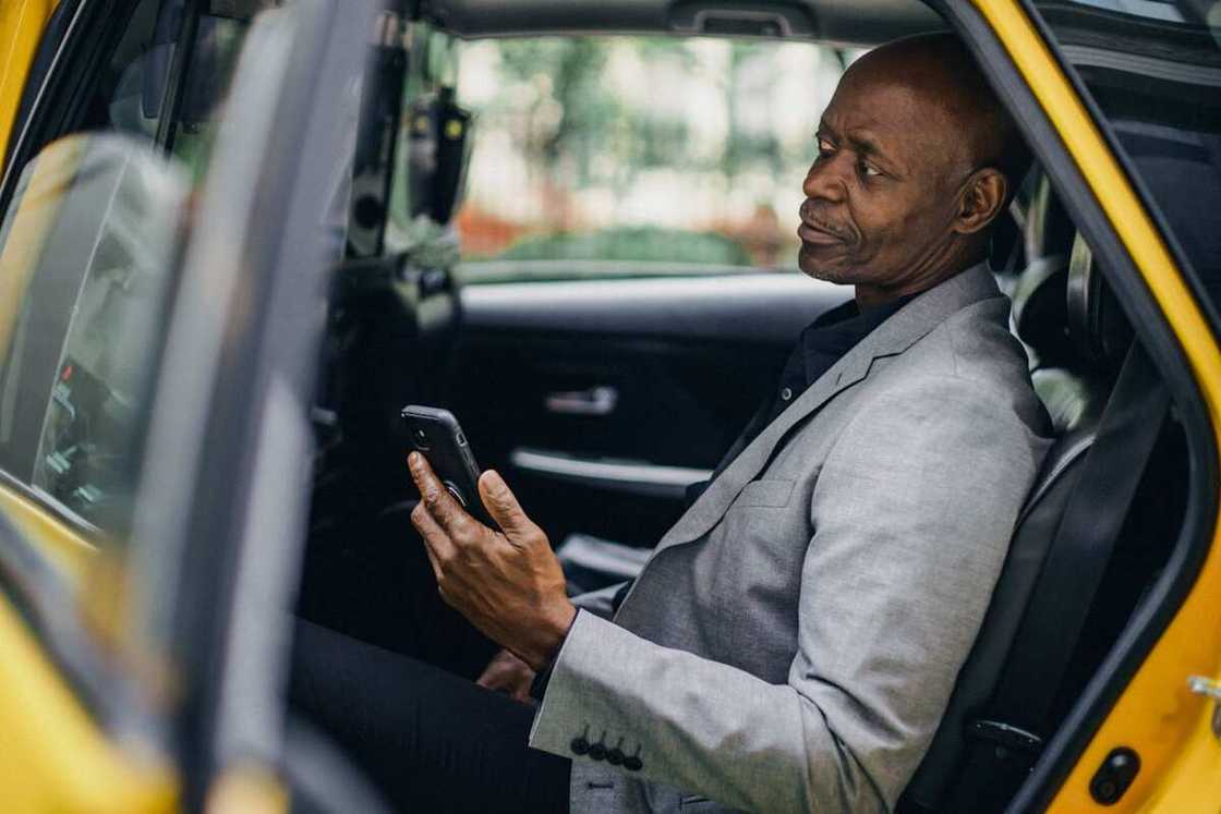 A man sitting in his car while using a phone A man sitting in his car while using a phone