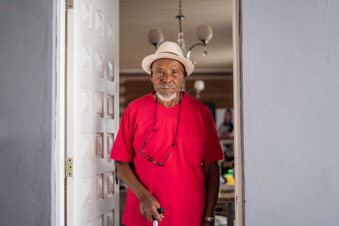 A man standing at the doorway with an expressionless face.