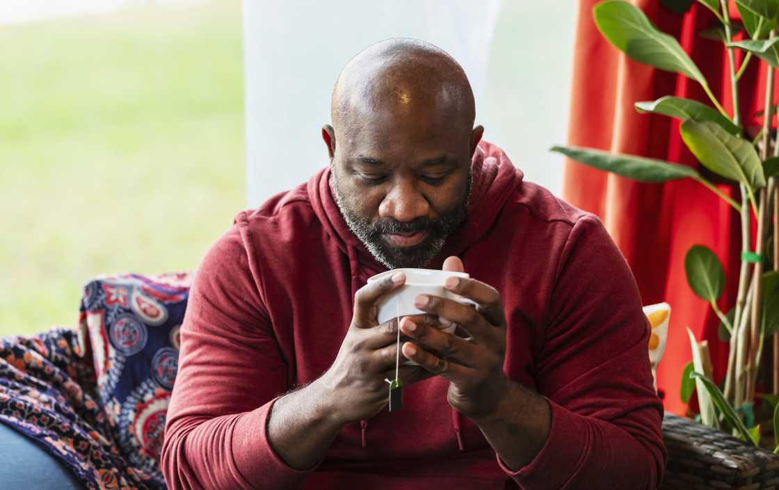A man is taking tea in the morning
