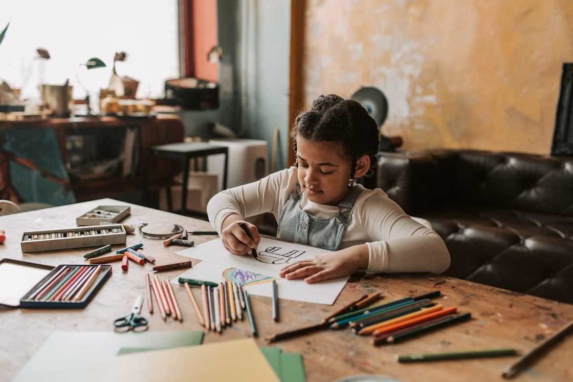 A girl draws at the kitchen table. A girl draws at the kitchen table.