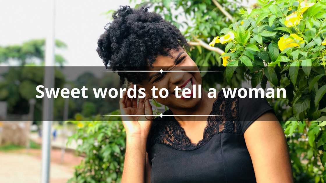 A happy Black woman in Afro hair and a black top laughing