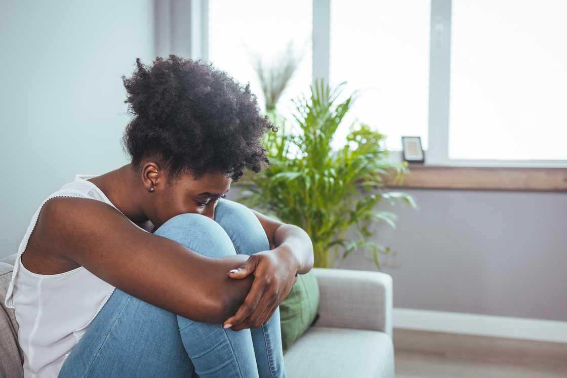 A lady is crying on the sofa