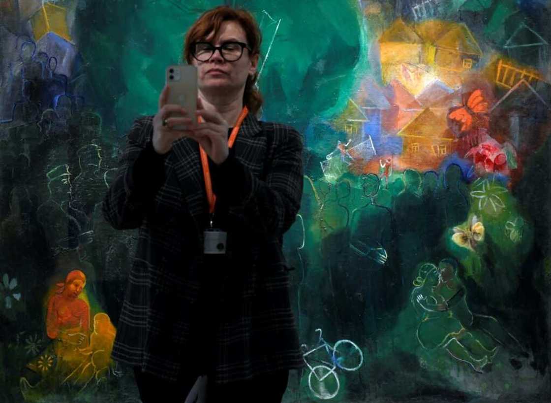 A journalist takes a picture near 'The 1st of May' by Viktor Palmov A journalist takes a picture near 'The 1st of May' by Viktor Palmov
