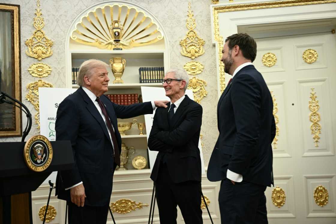 Apple, whose chief executive Tim Cook (C) met with President Donald Trump in the White House, is substantially boosting its investment commitment in the United States Apple, whose chief executive Tim Cook (C) met with President Donald Trump in the White House, is substantially boosting its investment commitment in the United States