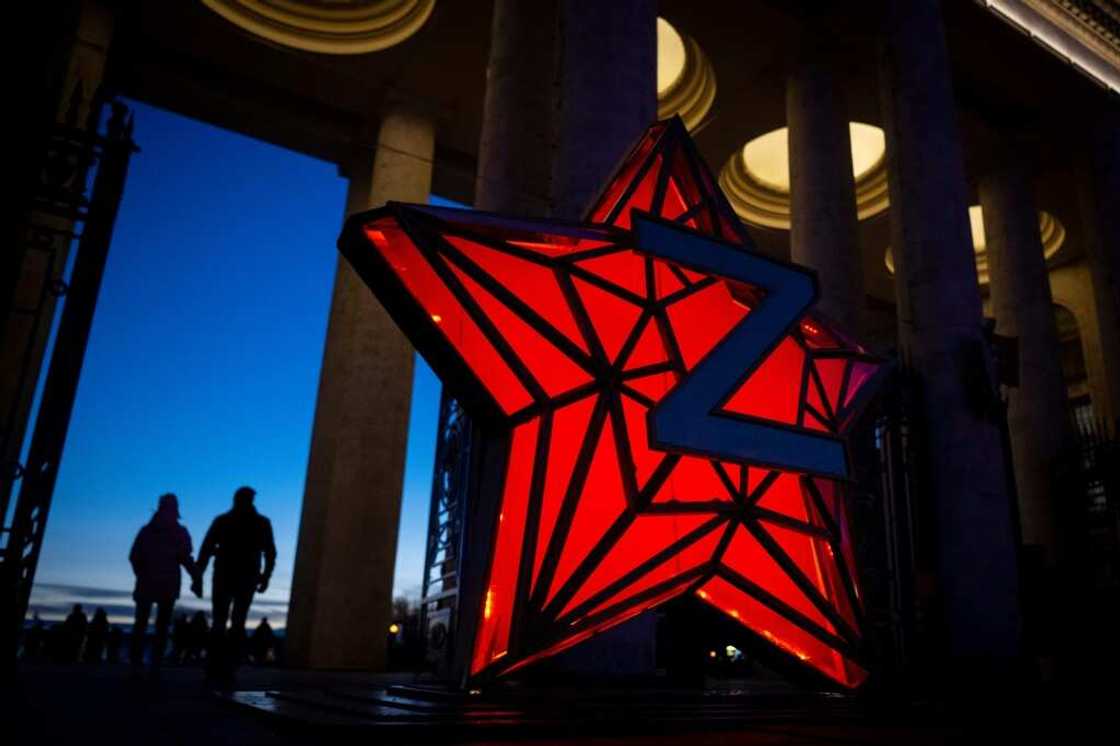 Pedestrians walk past a New Year decoration stylised as the 'Kremlin Star,' bearing a Z letter, a tactical insignia of Russian troops in Ukraine Pedestrians walk past a New Year decoration stylised as the 'Kremlin Star,' bearing a Z letter, a tactical insignia of Russian troops in Ukraine