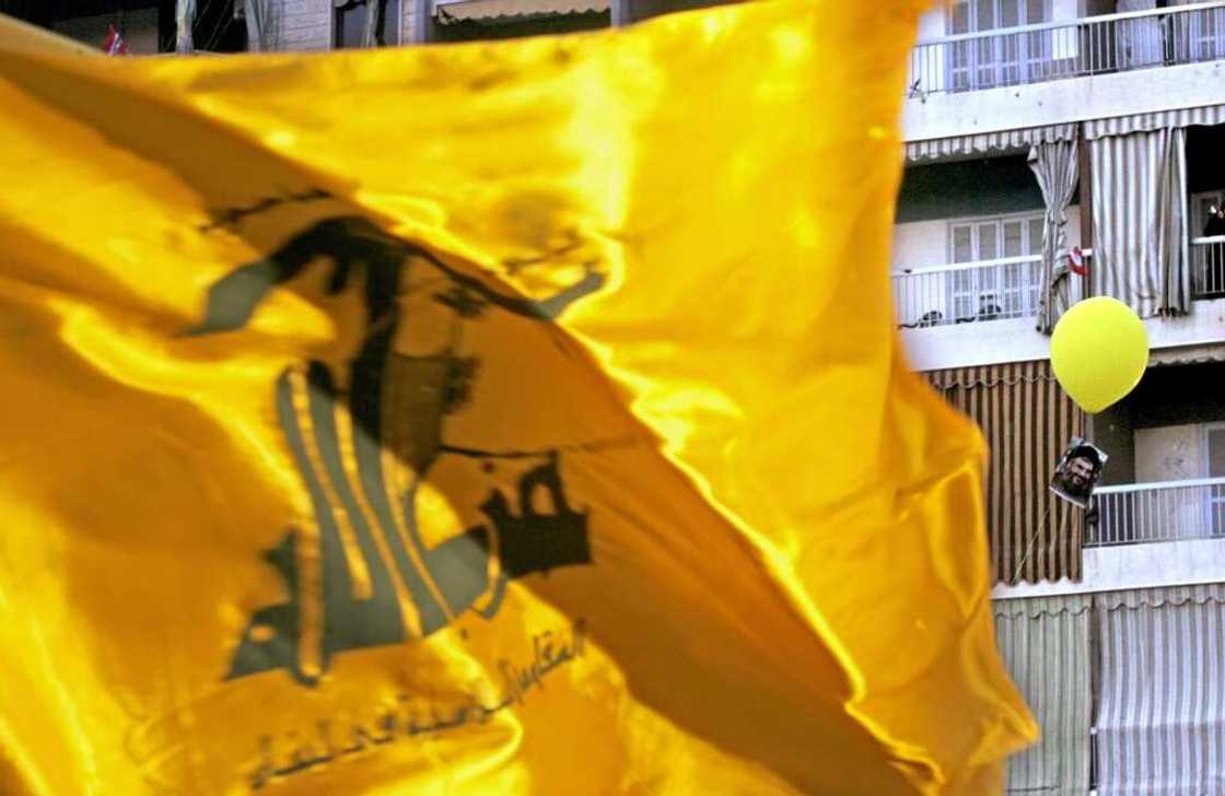 A Hezbollah flag flutters over a ceremony to mark the first anniversary of the war with Israel in Beirut's southern suburb of Dahiyeh, on August 14, 2007, while a portrait of Hezbollah chief Hassan Nasrallah tied to a balloon floats behind A Hezbollah flag flutters over a ceremony to mark the first anniversary of the war with Israel in Beirut's southern suburb of Dahiyeh, on August 14, 2007, while a portrait of Hezbollah chief Hassan Nasrallah tied to a balloon floats behind