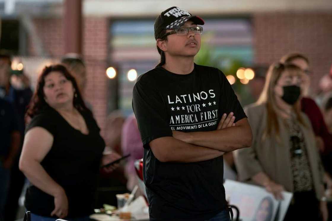 A man wearing a T-shirt that says, "Latinos for América First" attends a rally in McAllen, Texas, on October 10, 2022 A man wearing a T-shirt that says, "Latinos for América First" attends a rally in McAllen, Texas, on October 10, 2022