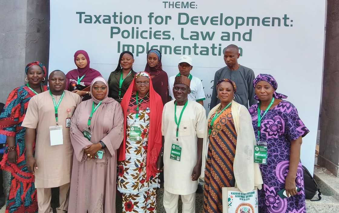 Tax officials pose standing infront of a banner. Tax officials pose standing infront of a banner.