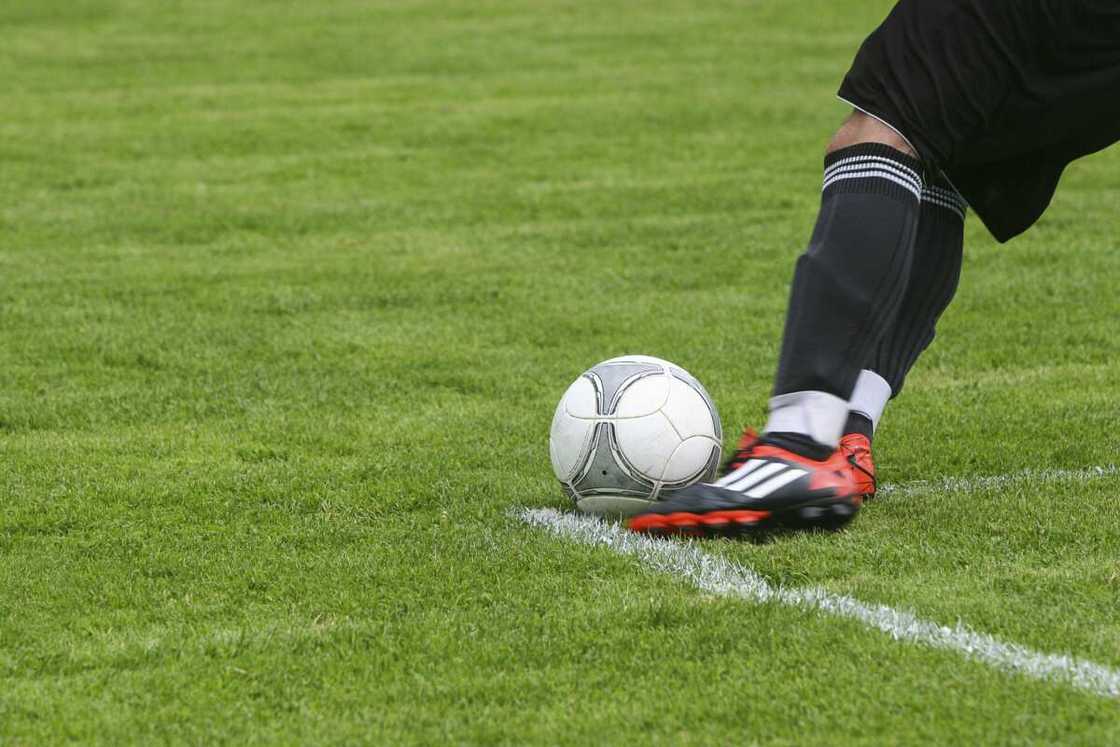 A person kicking a ball in the field