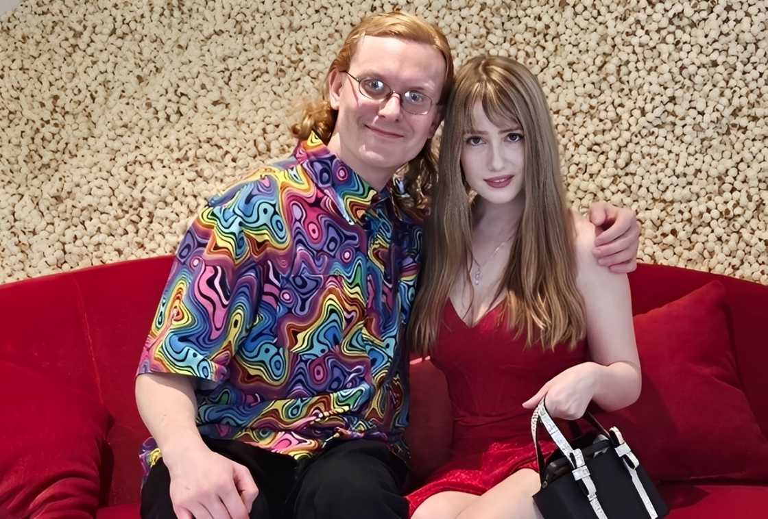 Jame and Shelley seated on a red couch Jame and Shelley seated on a red couch