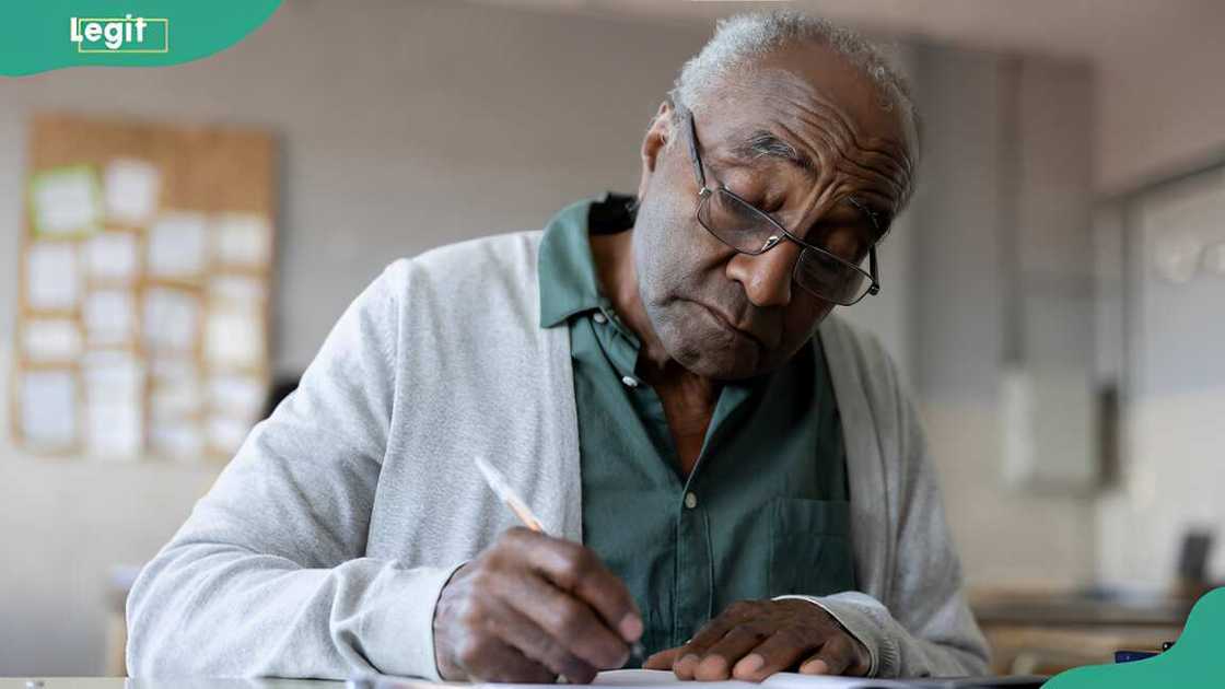 A senior man studying in college and writing his journal A senior man studying in college and writing his journal