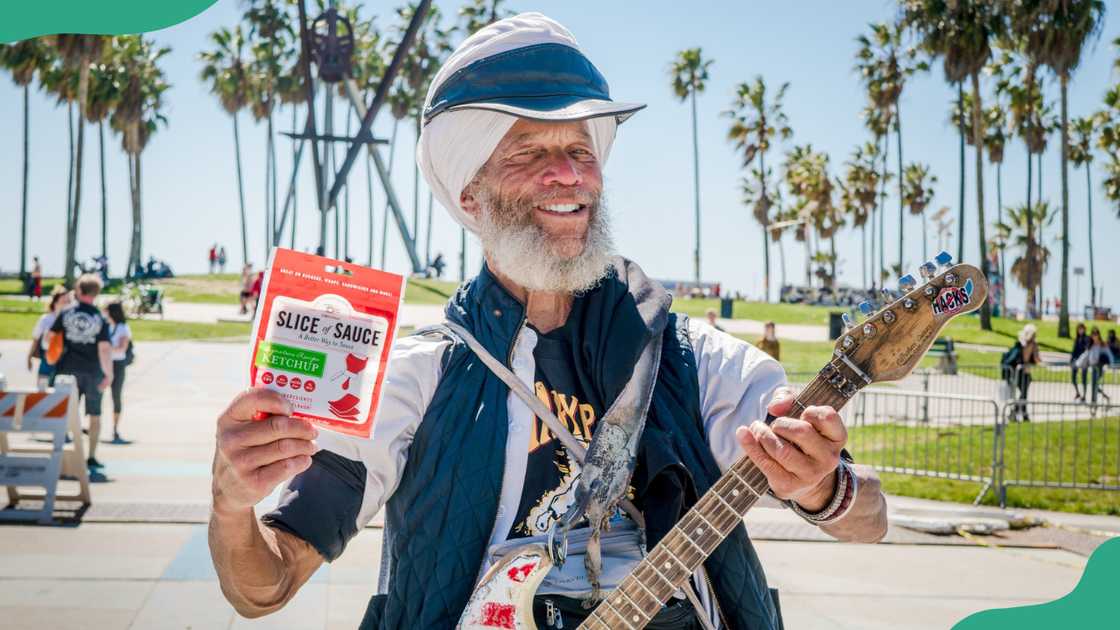 A man displays a sachet of Slice of Sauce