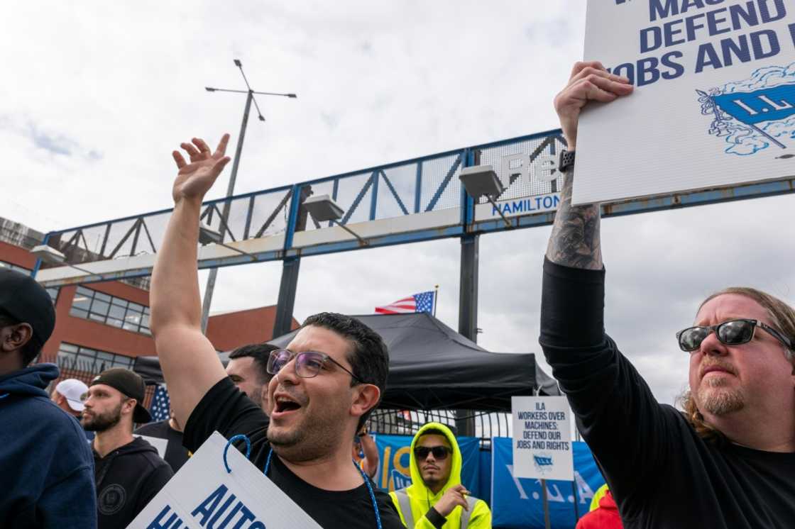 Striking workers at the Red Hook Container Terminal in Brooklyn, New York, gather after members of the International Longshoremen's Association began walking off the job